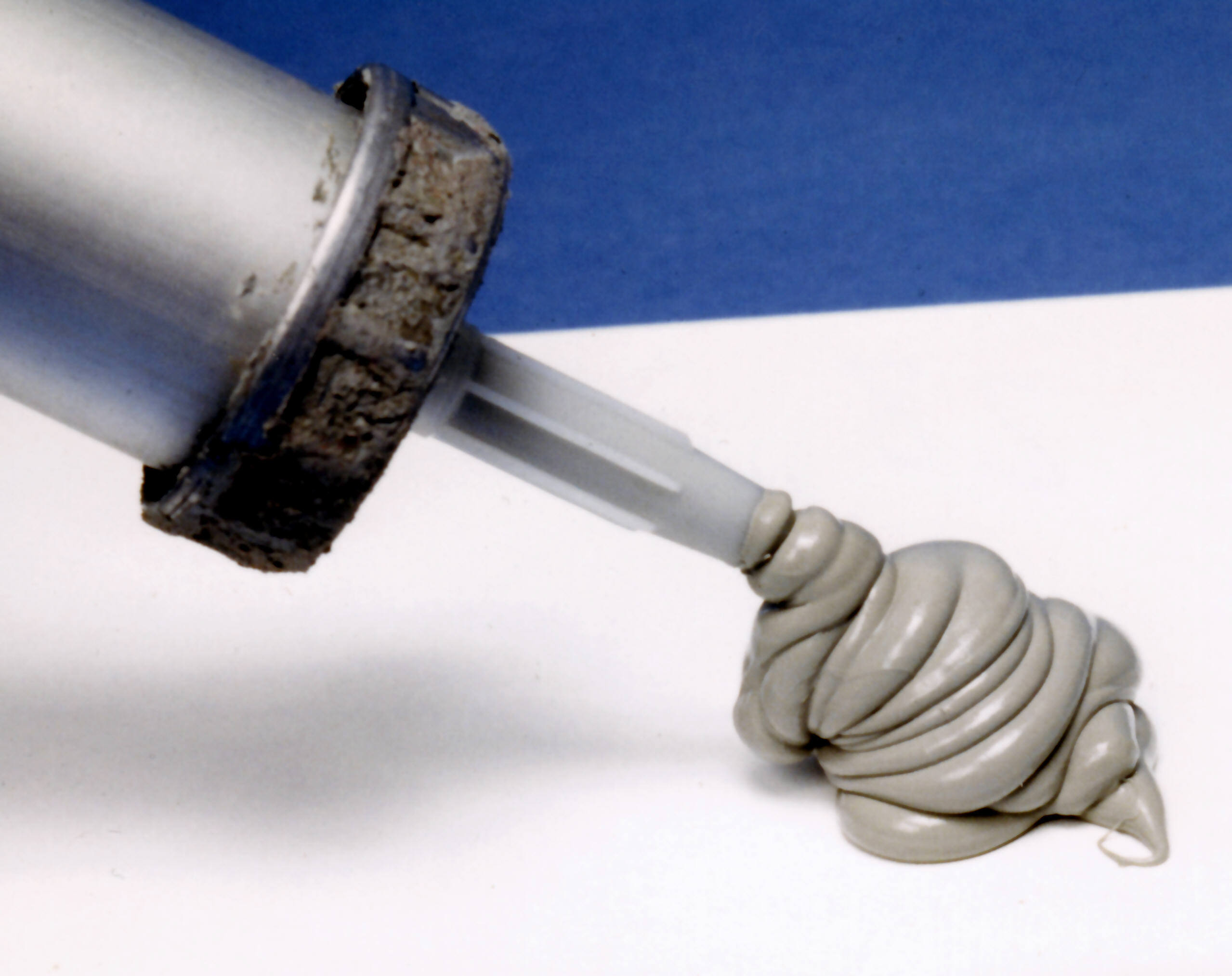 Silicone caulk from a tube, used in walls as a sealant & adhesive